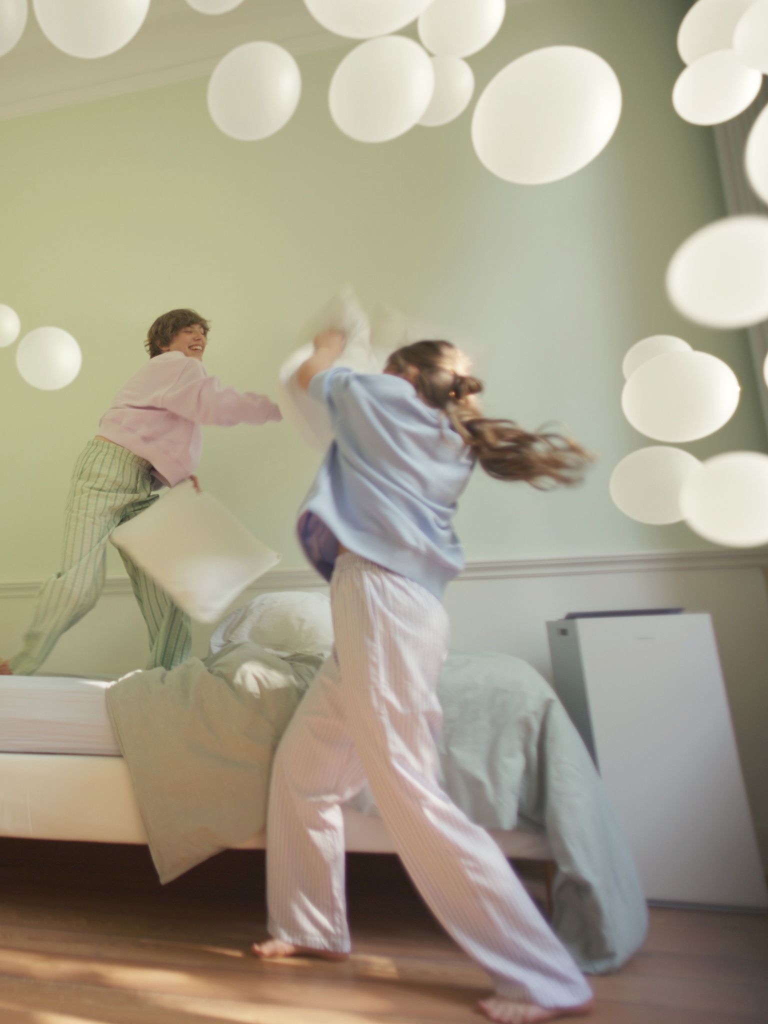 Dvě dívky si hrají v ložnici s vyváženou vlhkostí, kterou zajišťuje čistička vzduchu od Daikin.