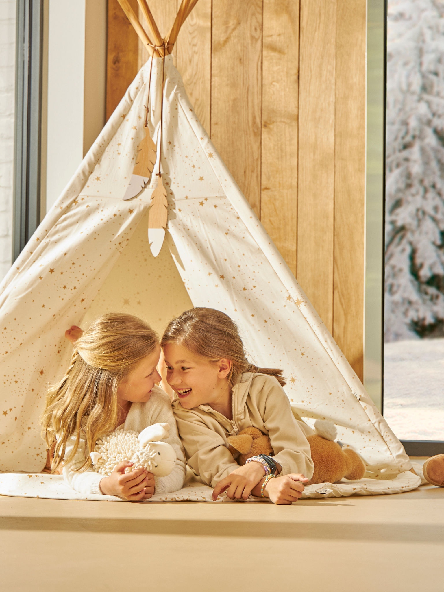 Dvě malé děti si spokojeně hrají v domácím stanu při ideální teplotě