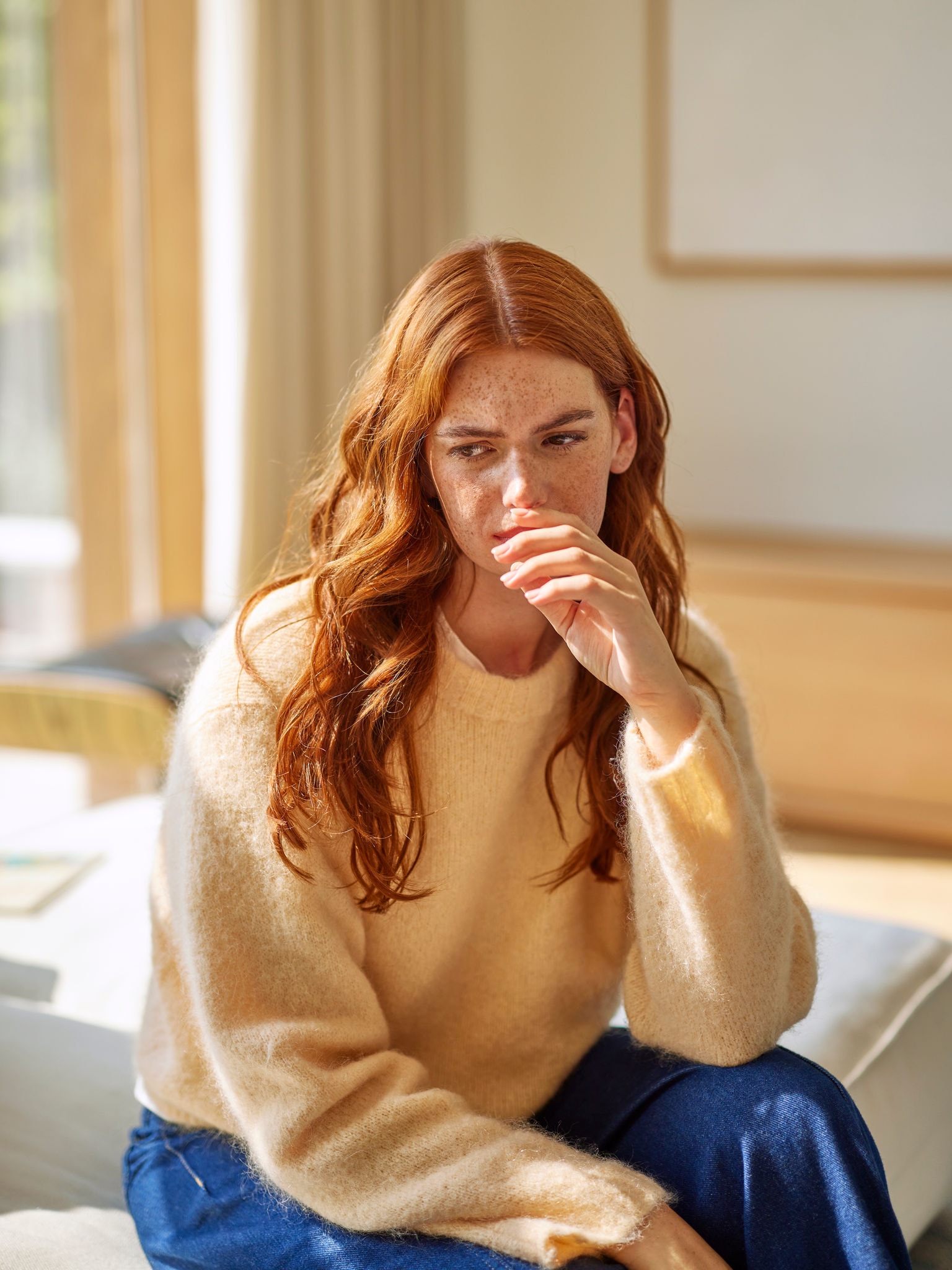 Žena reagující na nepříjemné pachy z vaření v obývacím pokoji