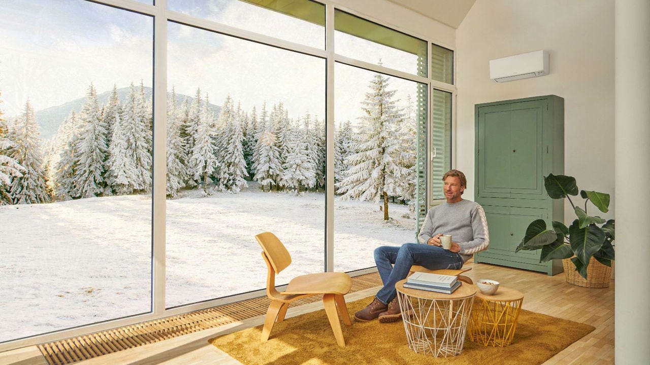 Muž sedí na pohovce a užívá si vytápění klimatizací.