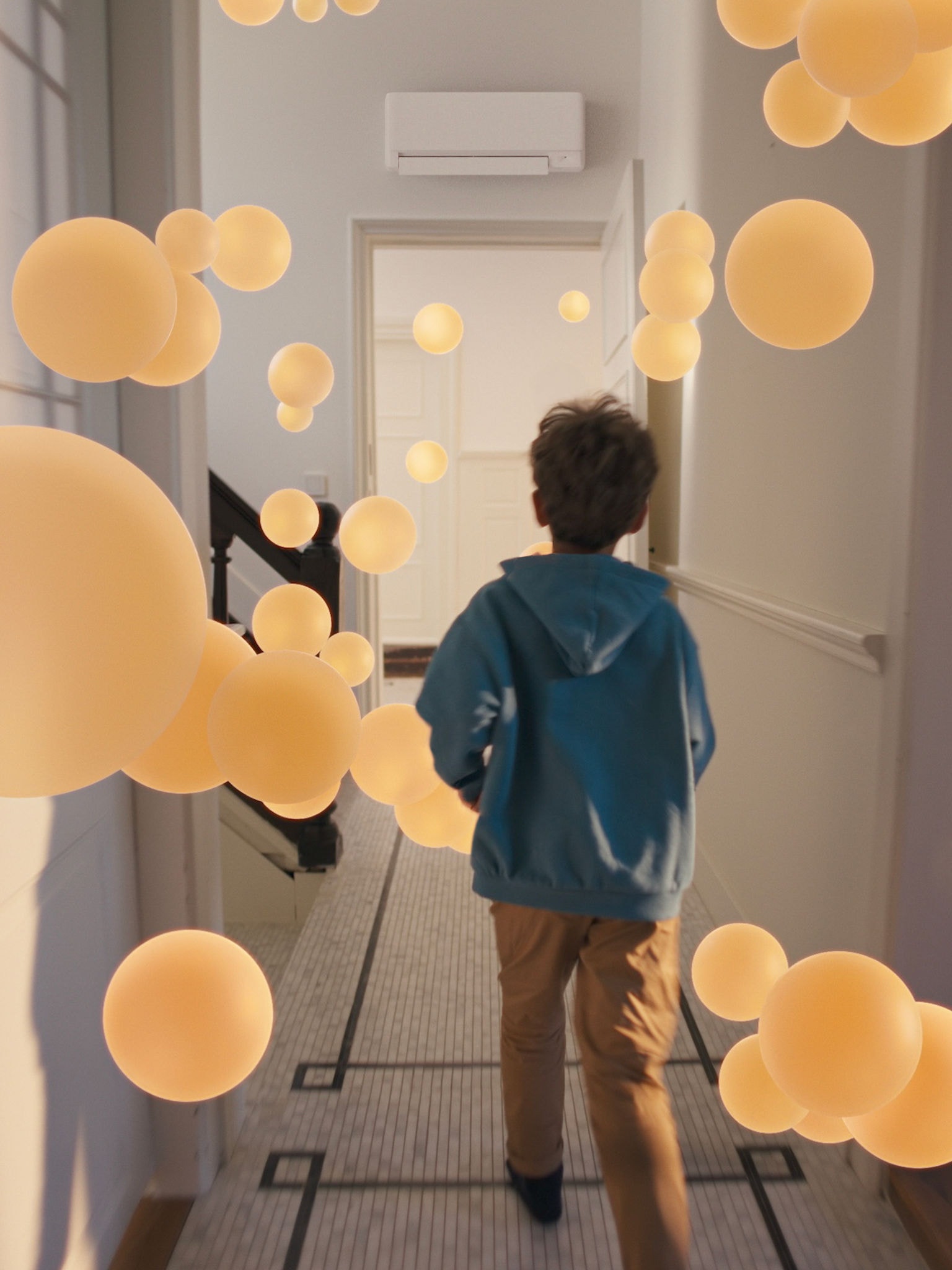 Chlapec procházející chodbou s rovnoměrným a vyváženým prouděním vzduchu, které umožňuje dobře navržený systém tepelného čerpadla vzduch-vzduch