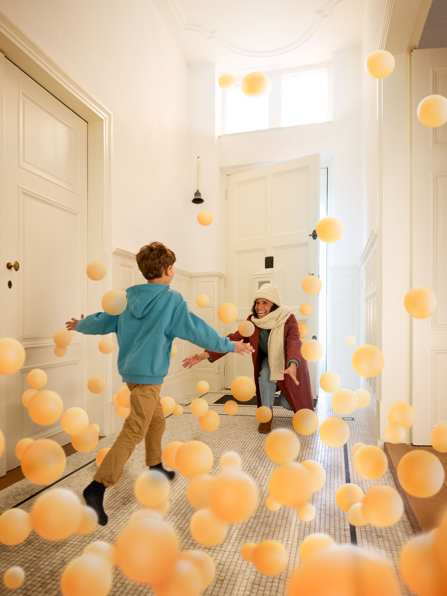 Syn objímá svou matku v příjemné chodbě, což symbolizuje pohodlí, teplo a neviditelný vliv čistého, dokonale vyváženého vzduchu v interiéru od společnosti Daikin