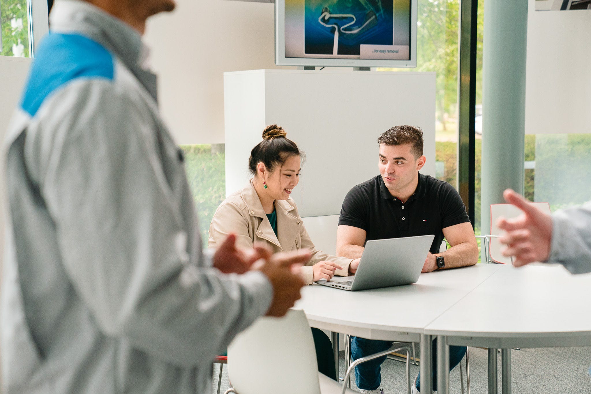 Žena vysvětluje muži něco na notebooku