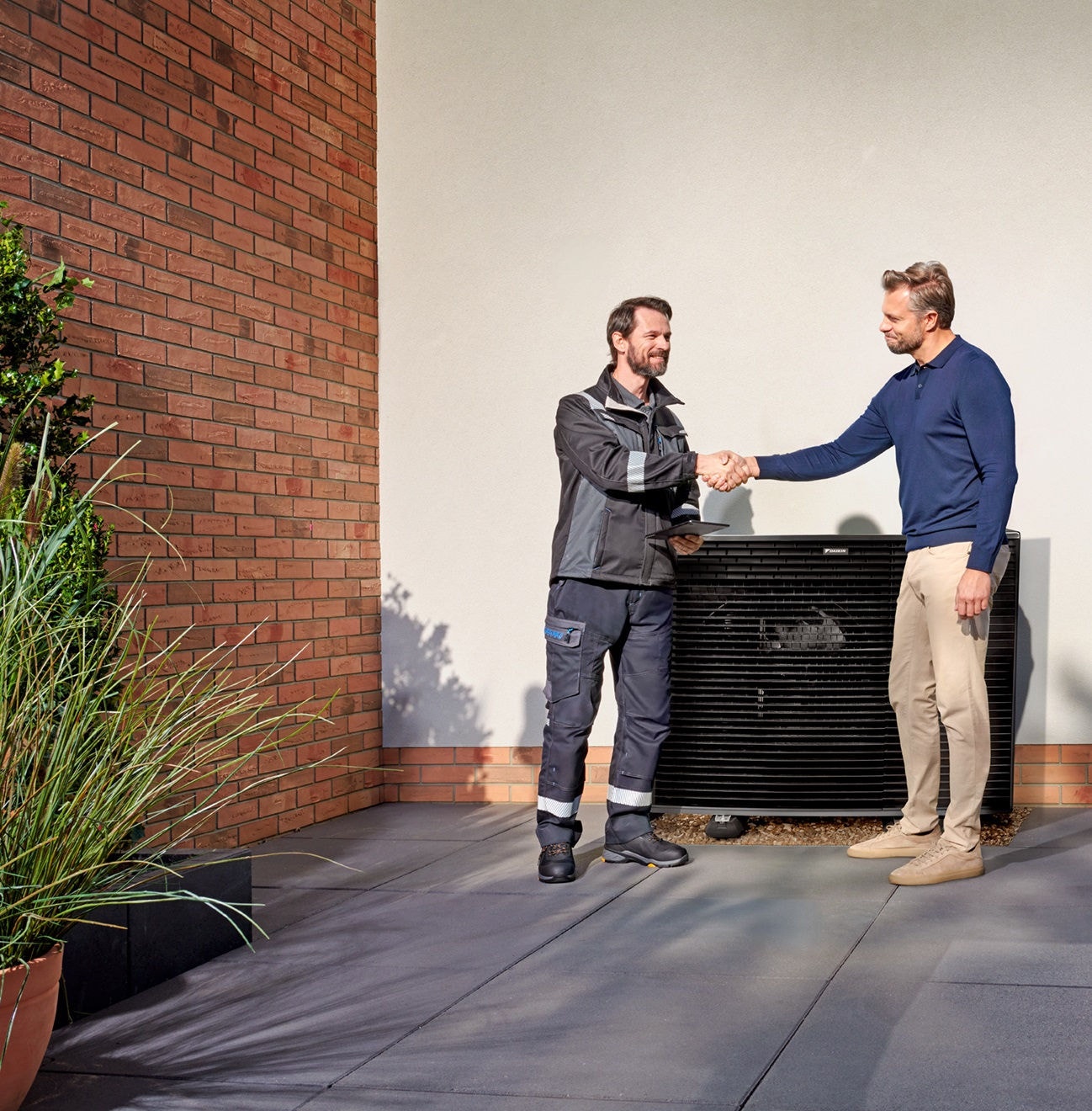 Muž se sluchátky na uších leží na pohovce a prohlíží si mobilní telefon.