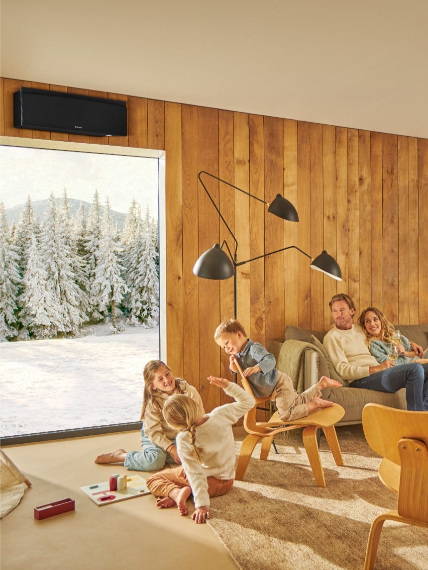 Rodina si užívá čistý vzduch v interiéru s čističkou vzduchu Daikin – zatímco děti hrají šachy, dospělí odpočívají u nápojů ve světlém, dobře větraném obývacím pokoji.