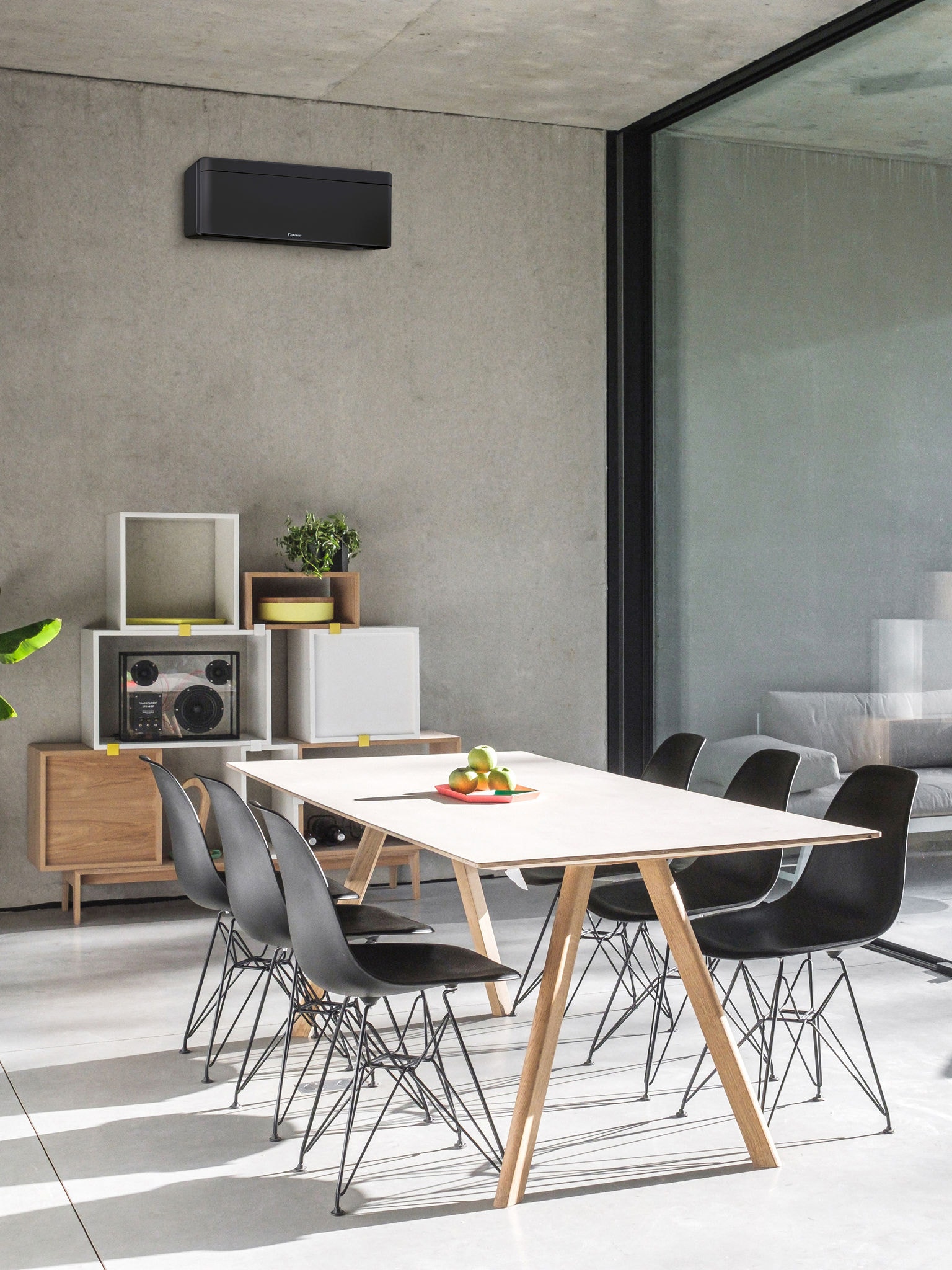 Jídelna s velkým oknem a instalovaným nástěnným tepelným čerpadlem vzduch-vzduch