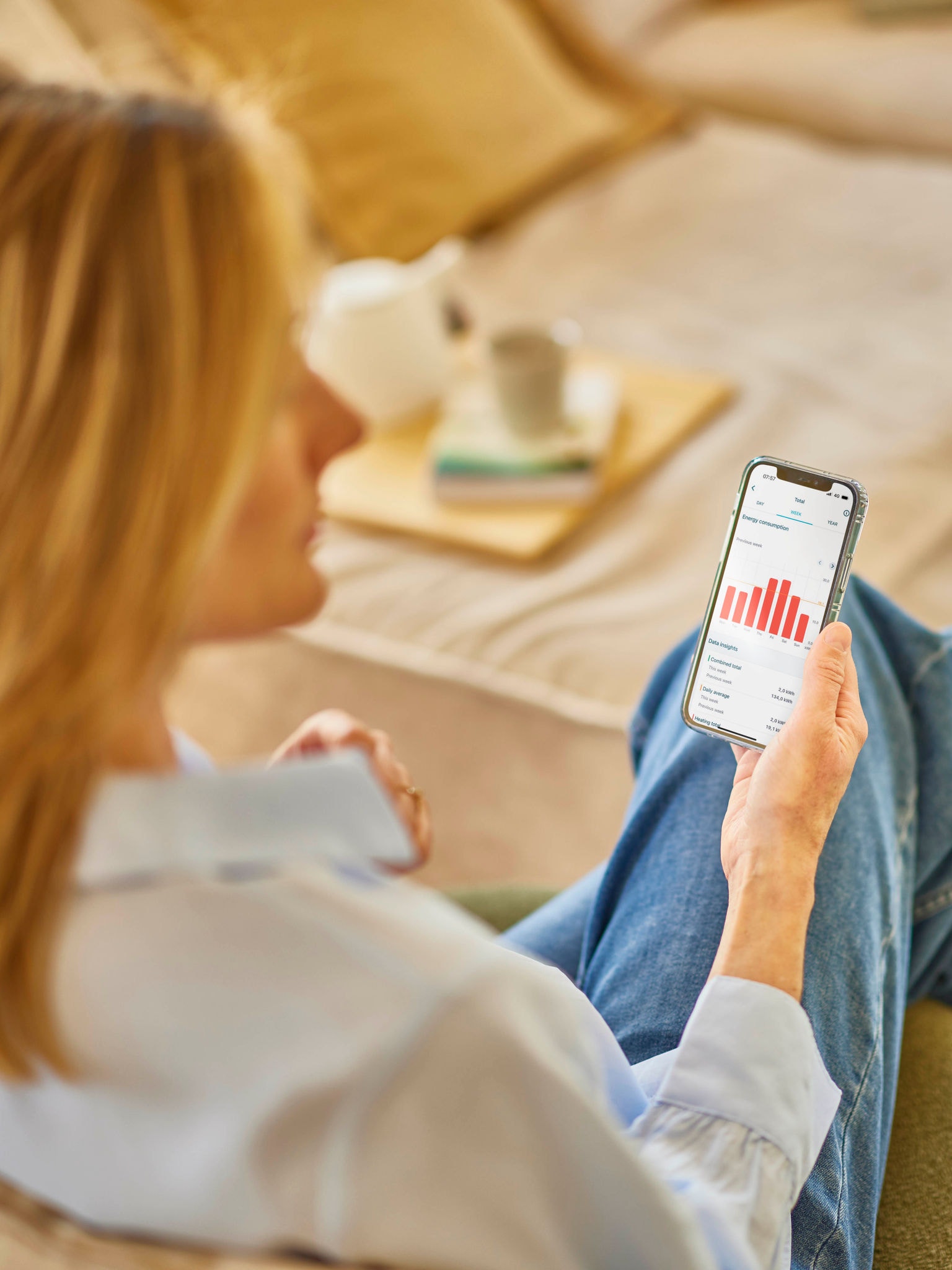 Blondýna sleduje svou spotřebu energie v aplikaci na svém telefonu