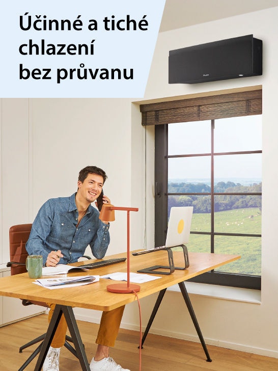 Muž se sluchátky na uších leží na pohovce a prohlíží si mobilní telefon.