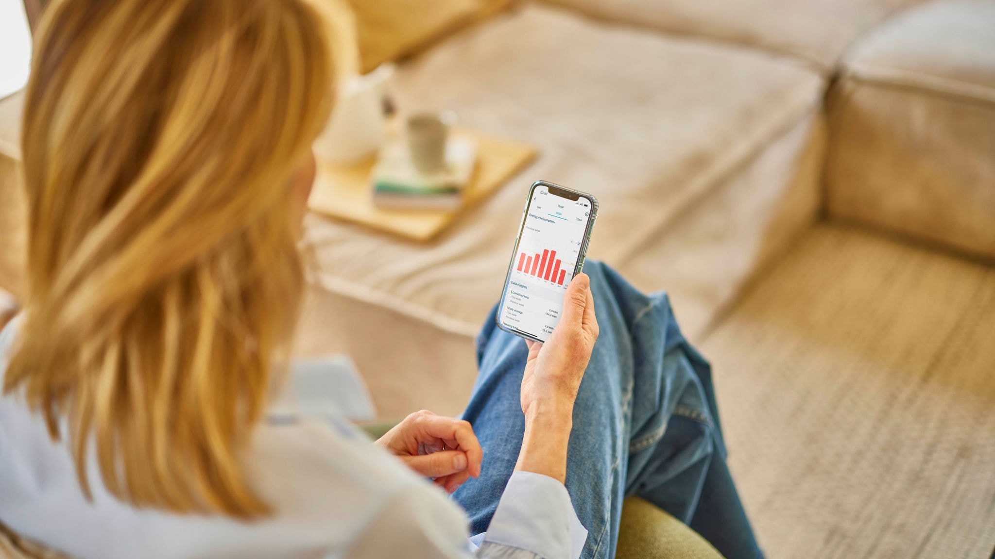 Žena ovládající svou ventilační jednotku pomocí aplikace Onecta