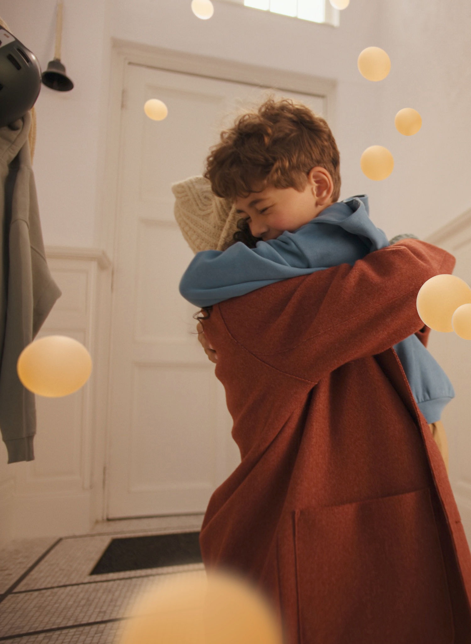 Matka a syn si užívají vřelé objetí ve stylovém a klidném obývacím prostoru a užívají si tichého komfortu tepelného čerpadla Daikin vzduch-vzduch