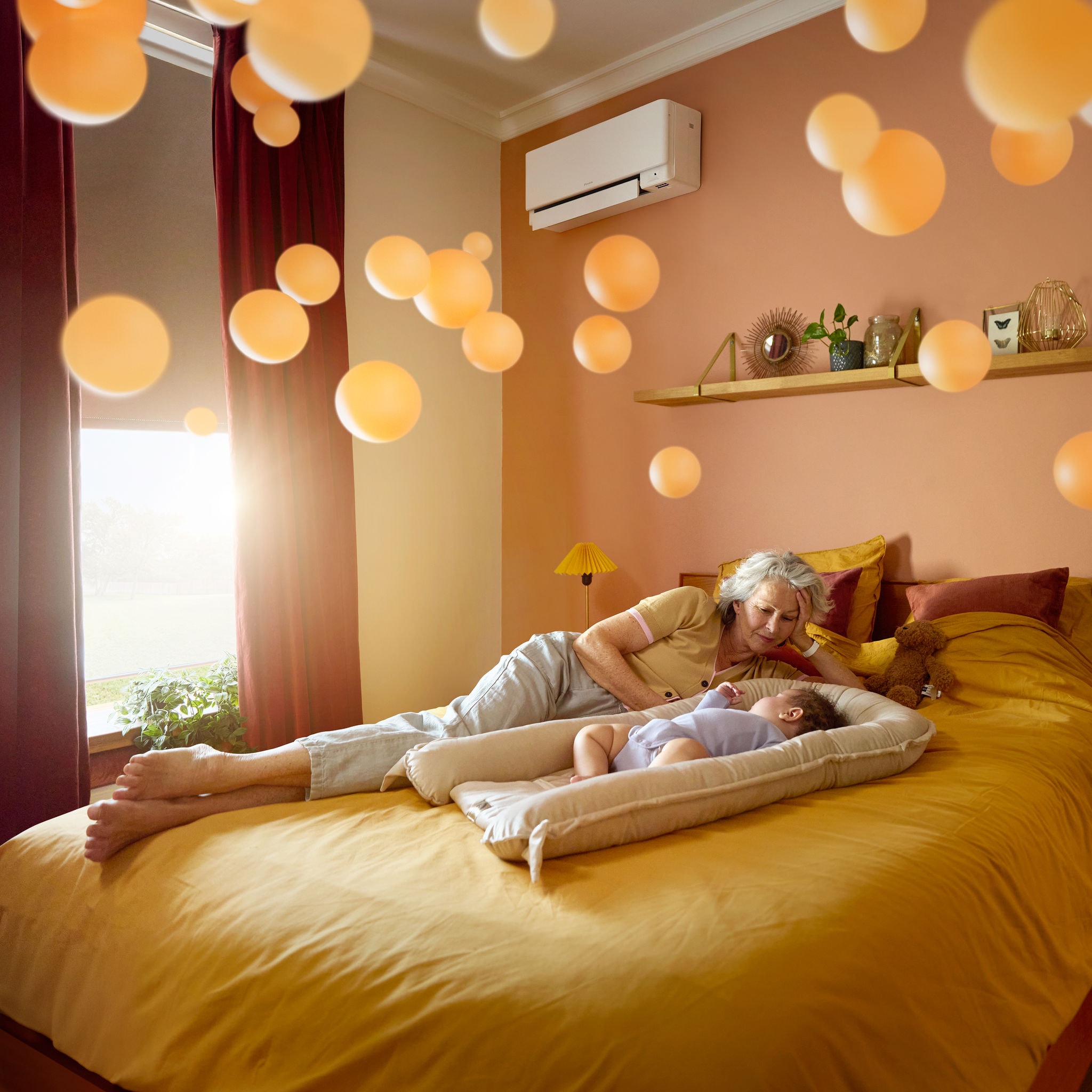 Babička ležící vedle klidně spícího dítěte v tiché, příjemně vyhřáté místnosti díky tichému tepelnému čerpadlu vzduch-vzduch