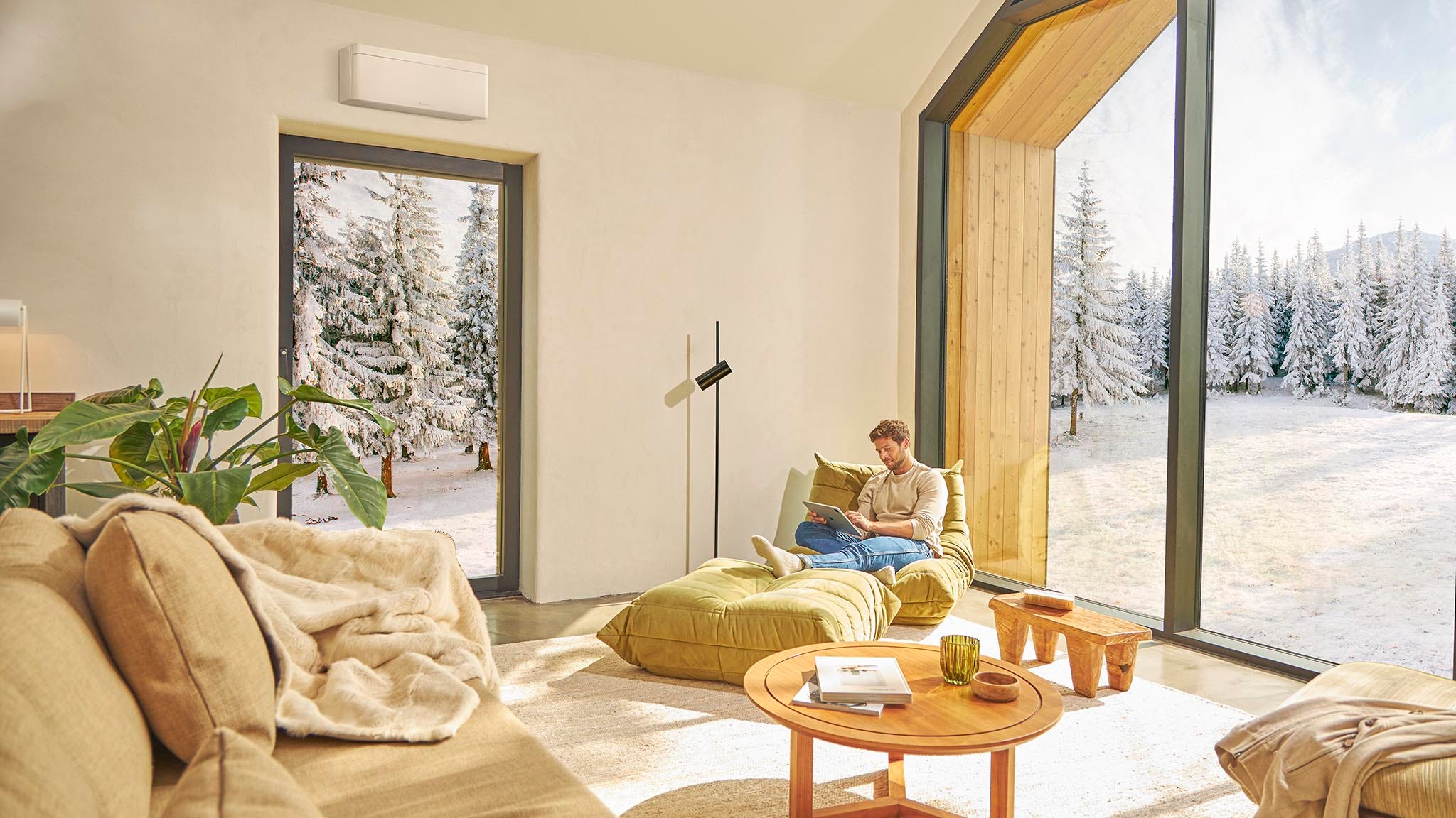 Muž sedí na pohovce a užívá si vytápění klimatizací.