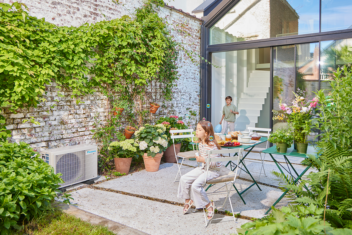 Děti hrající kuličky na zahradní terase vedle venkovního tepelného čerpadla