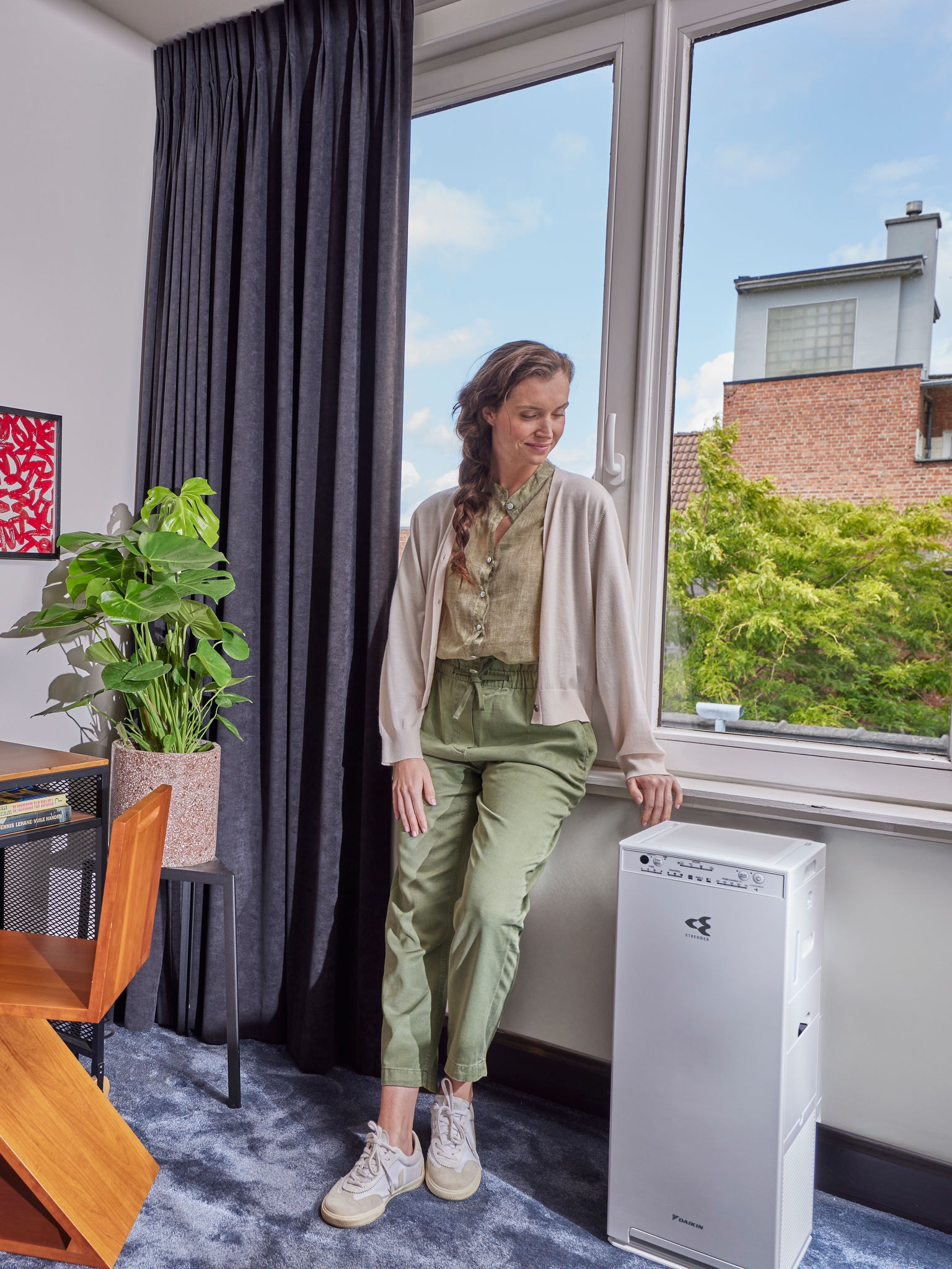 Žena stojící vedle své čističky vzduchu