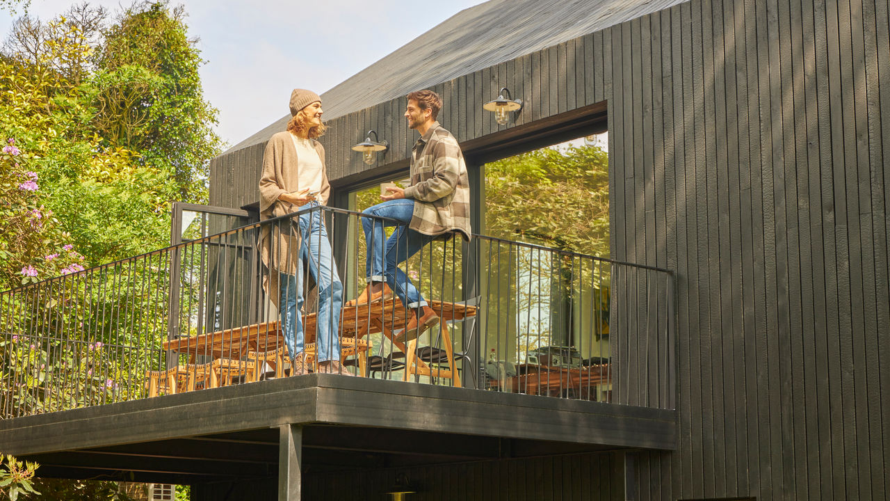 Pár diskutující na terase bungalovu v přírodě